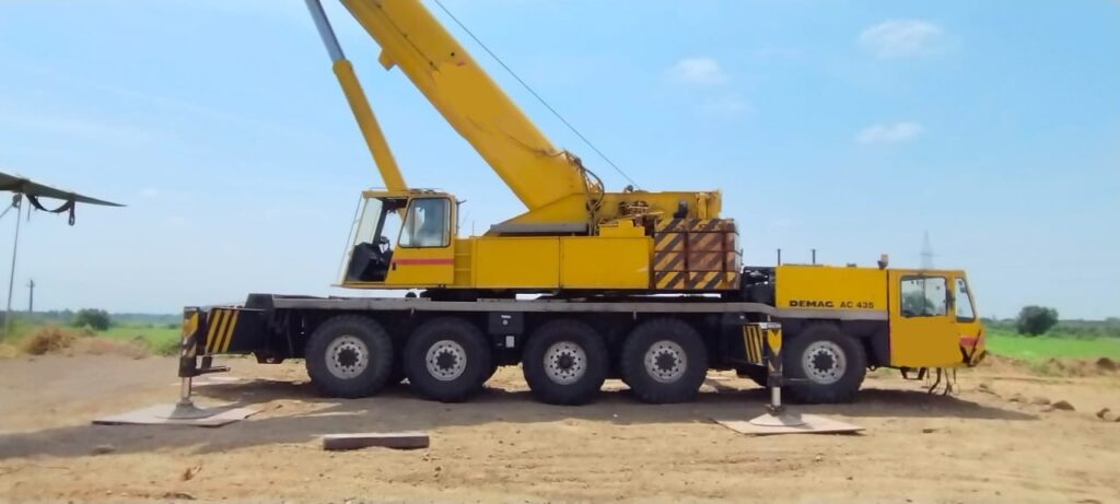 A used crane at a construction site with a checklist of important buying factors.