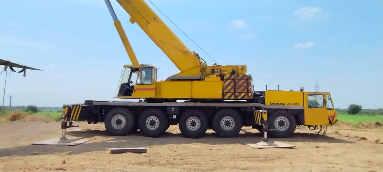A used crane at a construction site with a checklist of important buying factors.